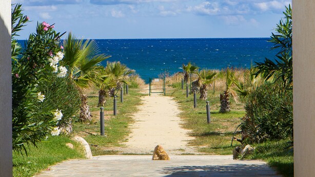 A pathway leading to a beach with a clear view of the ocean. - Villa Climatisée T3 Piscine Chauffée Accès Direct à la Plage de Prunete (Cervione)