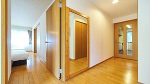 A hotel room with a wooden floor, a bed, a wardrobe, and a mirror. - The Prime TOKYO HANEDA (Tokyo)