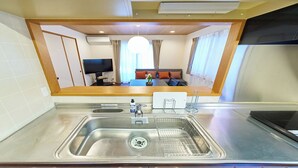 A modern kitchen with a stainless steel sink, a built-in microwave, and a small countertop area. - The Prime TOKYO HANEDA (Tokyo)