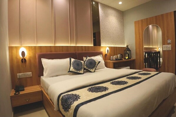 A hotel room with a large bed, wooden headboard, bedside lamps, and a mirror. - Narison Hotel By Divud Ecom (Amritsar)