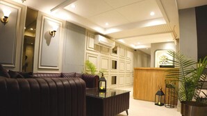 Een moderne lobby met een leren bank, een glazen salontafel en een receptiebalie.