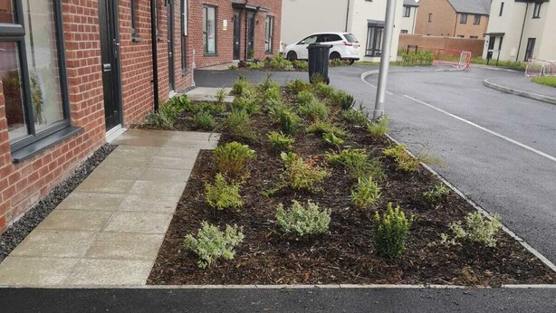 A residential street with houses, a sidewalk, and a landscaped garden area. - Full house- Free Parking, Wifi, and appliances to make your stay comfortable. (Hull)