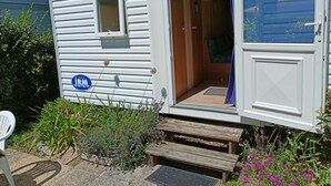 Ein kleines, eingeschossiges Haus mit offener Tür zu einem Zimmer.
