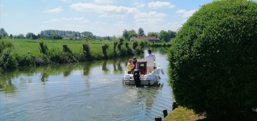 Un canal estrecho con una pequeña embarcación transportando pasajeros.