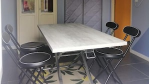 A dining area with a table and four chairs, a cabinet with glass doors, and a patterned rug.