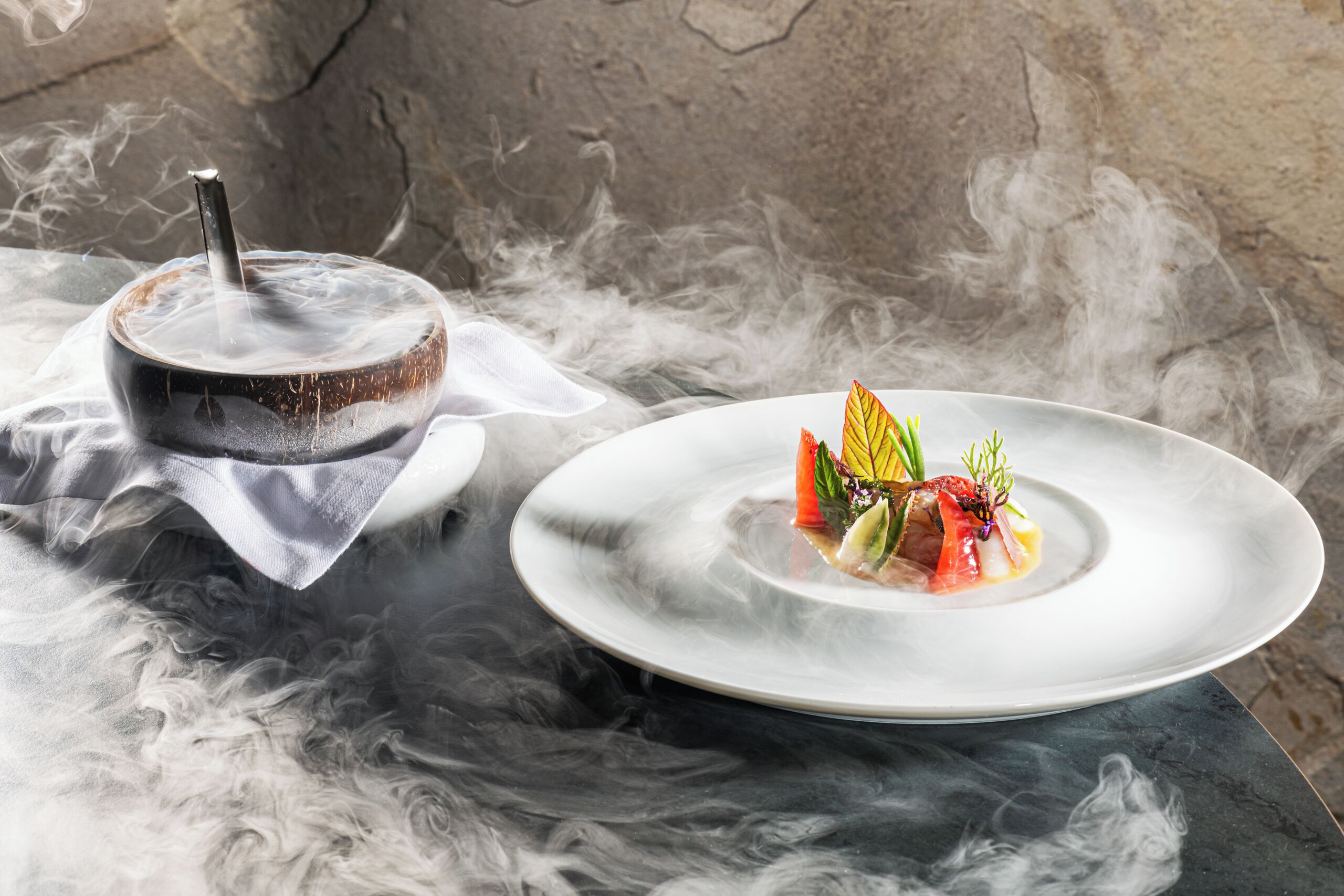 A dining table with a plate of food and a smoking device.