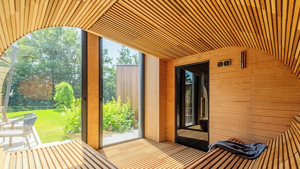 Un interior moderno de madera con un amplio ventanal que da a un jardín.