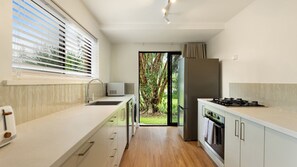 A modern kitchen with a built-in oven, a microwave, and a sink.