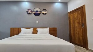 Un dormitorio con una cama grande, un cabecero de madera y un armario de madera.