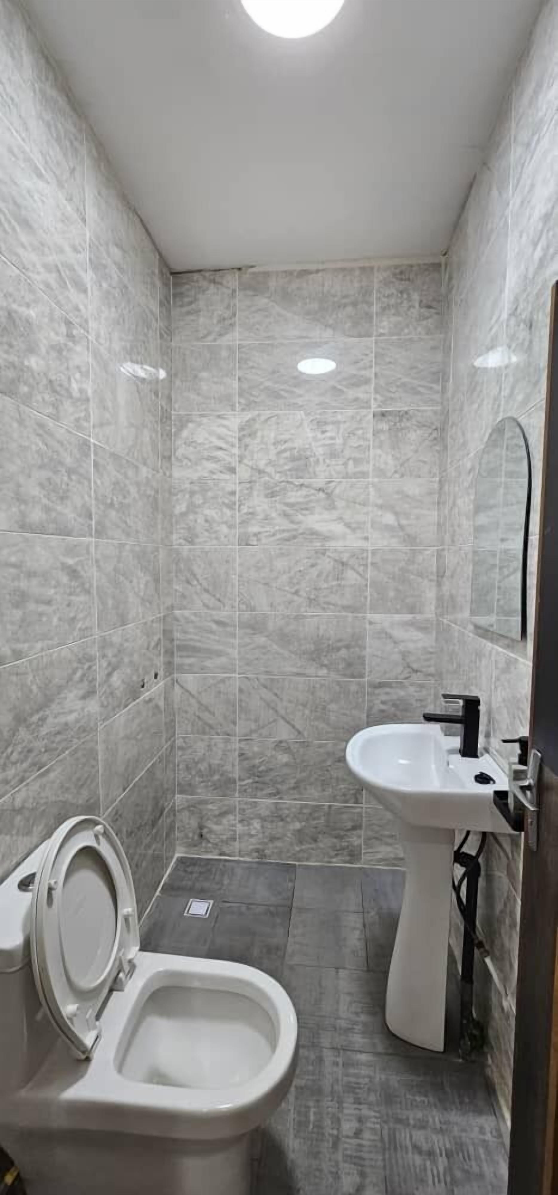 Un baño con inodoro, bidé y lavamanos, todo en blanco.