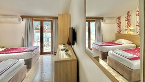 A hotel room with two beds, a wooden desk, a TV, and a large mirror. - Hotel Grbalj (Budva)