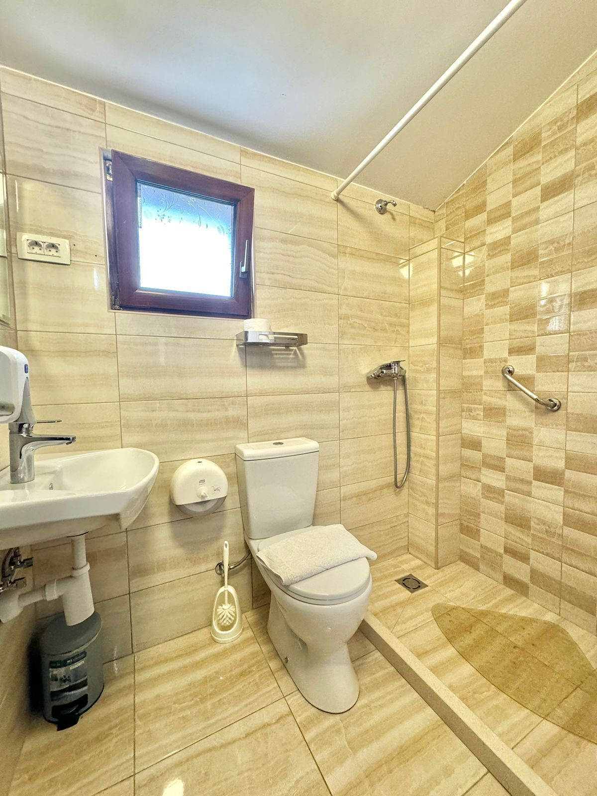 Un baño moderno con inodoro, lavamanos y ducha.