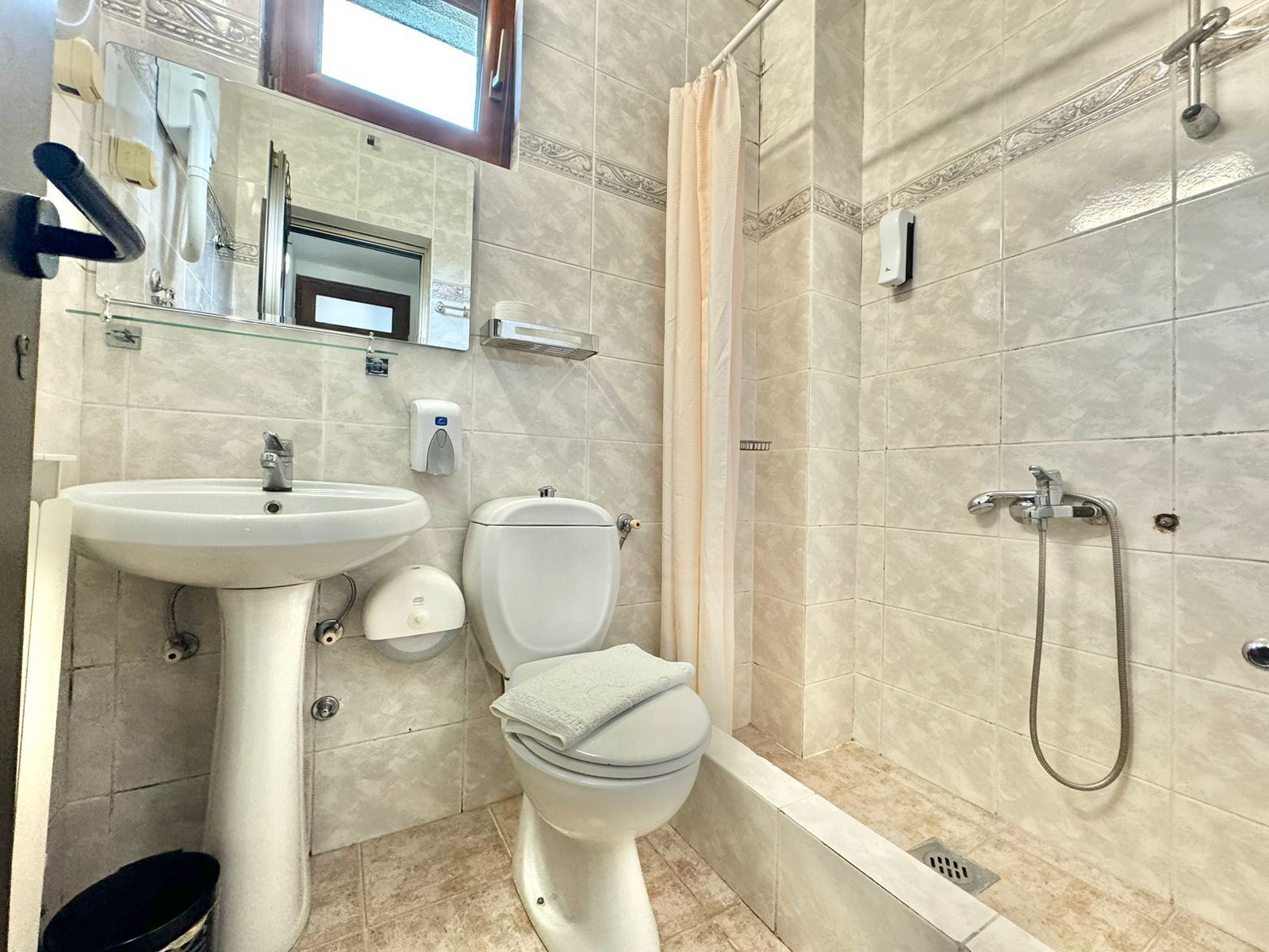 Un baño con lavamanos, inodoro y ducha.