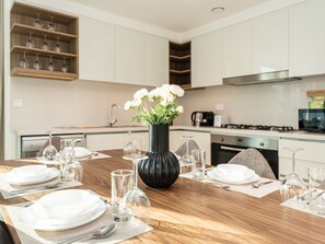Deluxe appartement | Privékeuken | Een koelkast met diepvriezer, een microgolfoven, een oven, een kookplaat