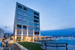 A modern hotel with a poolside area, outdoor seating, and a view of the sea. - Residenza Du Lac - Serviced Apartments (Paradiso)