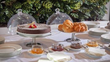 Ein Büfett mit Schokoladenkuchen, Croissants und verschiedenen Marmeladen und Aufstrichen.