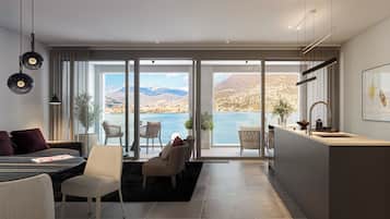 A modern living room with a large sliding glass door leading to a balcony with a lake view.