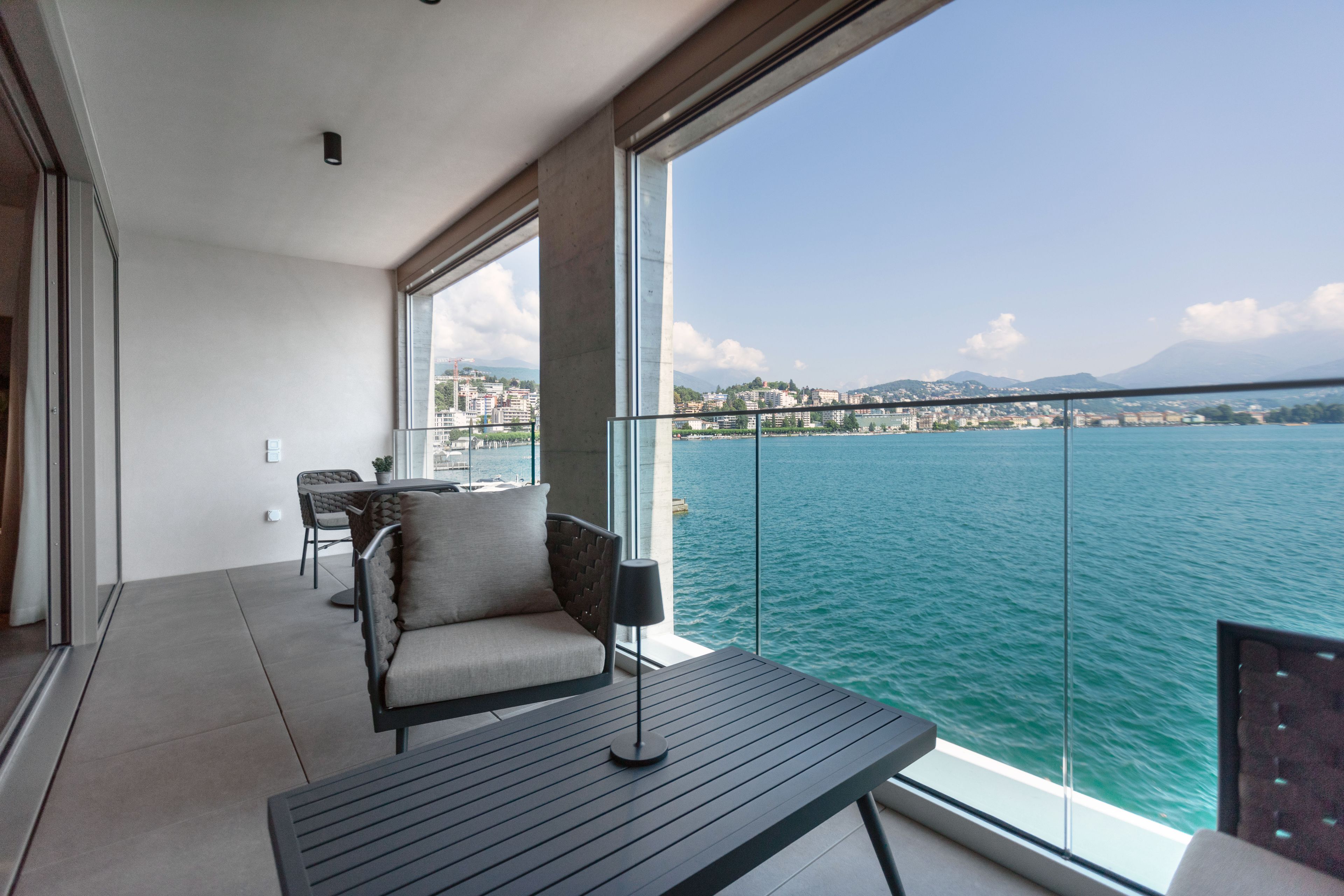 Ein Balkon mit Blick auf ein Gewässer und eine Stadtansicht.