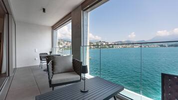 Ein Balkon mit Blick auf ein Gewässer und eine Stadtansicht.