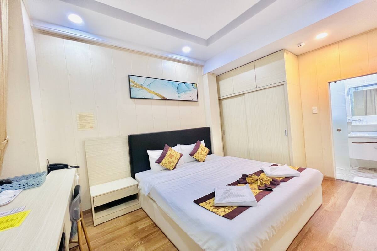 Ein Hotelzimmer mit Bett, Nachttisch und einem Bild an der Wand.