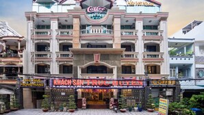 A multi-story building with a prominent coffee shop sign at the entrance. - Truc Huyen Hotel (Ho Chi Minh City)