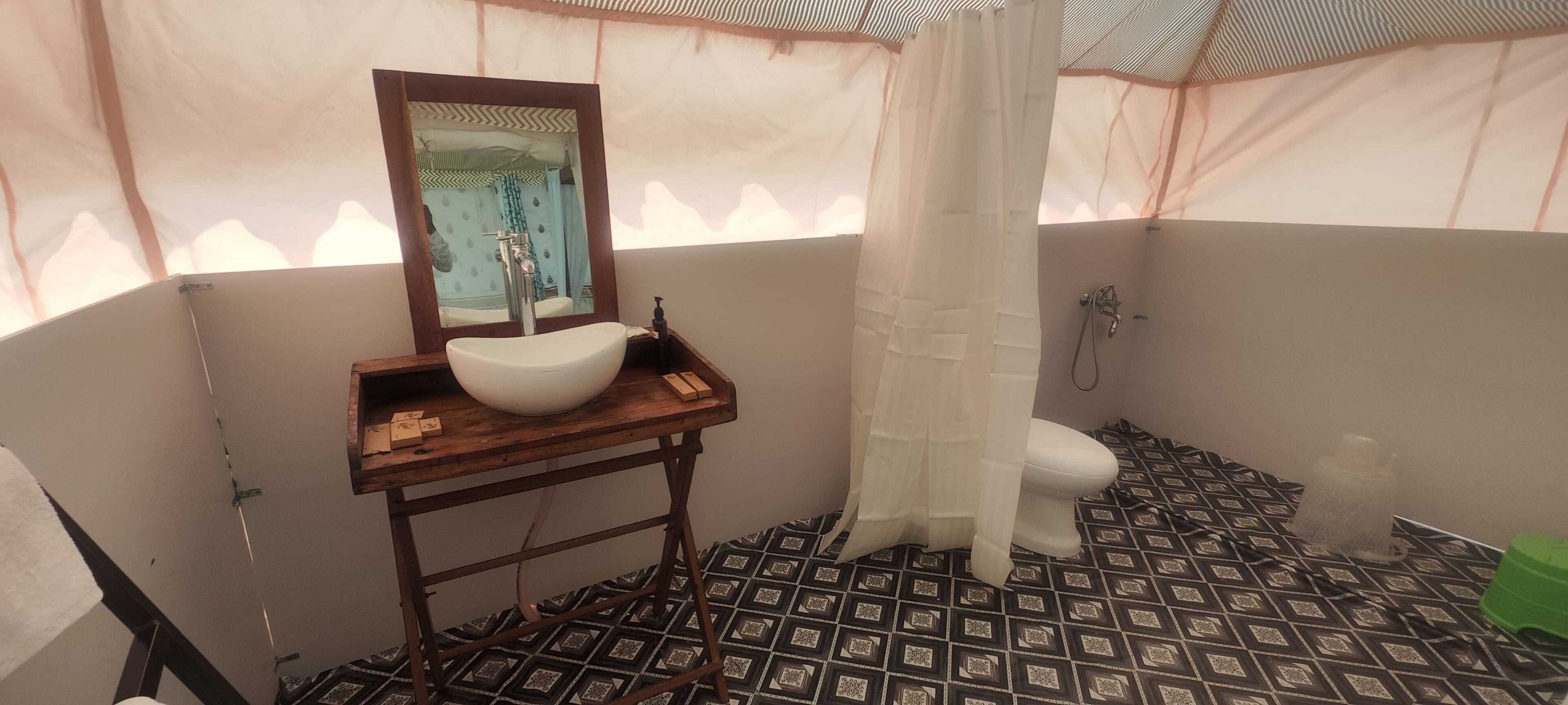 Un baño con tocador de madera, un espejo grande, un lavamanos blanco, un inodoro y una zona de ducha.