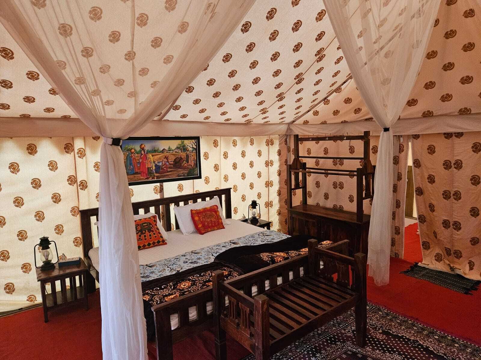 Ein traditionell eingerichtetes Zimmer mit einem Holzbett, einem Gemälde an der Wand und raumhoch wirkender Tapete.