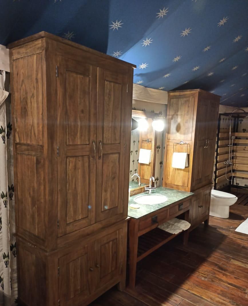Un baño con armarios de madera, un lavabo, un espejo y una ducha.