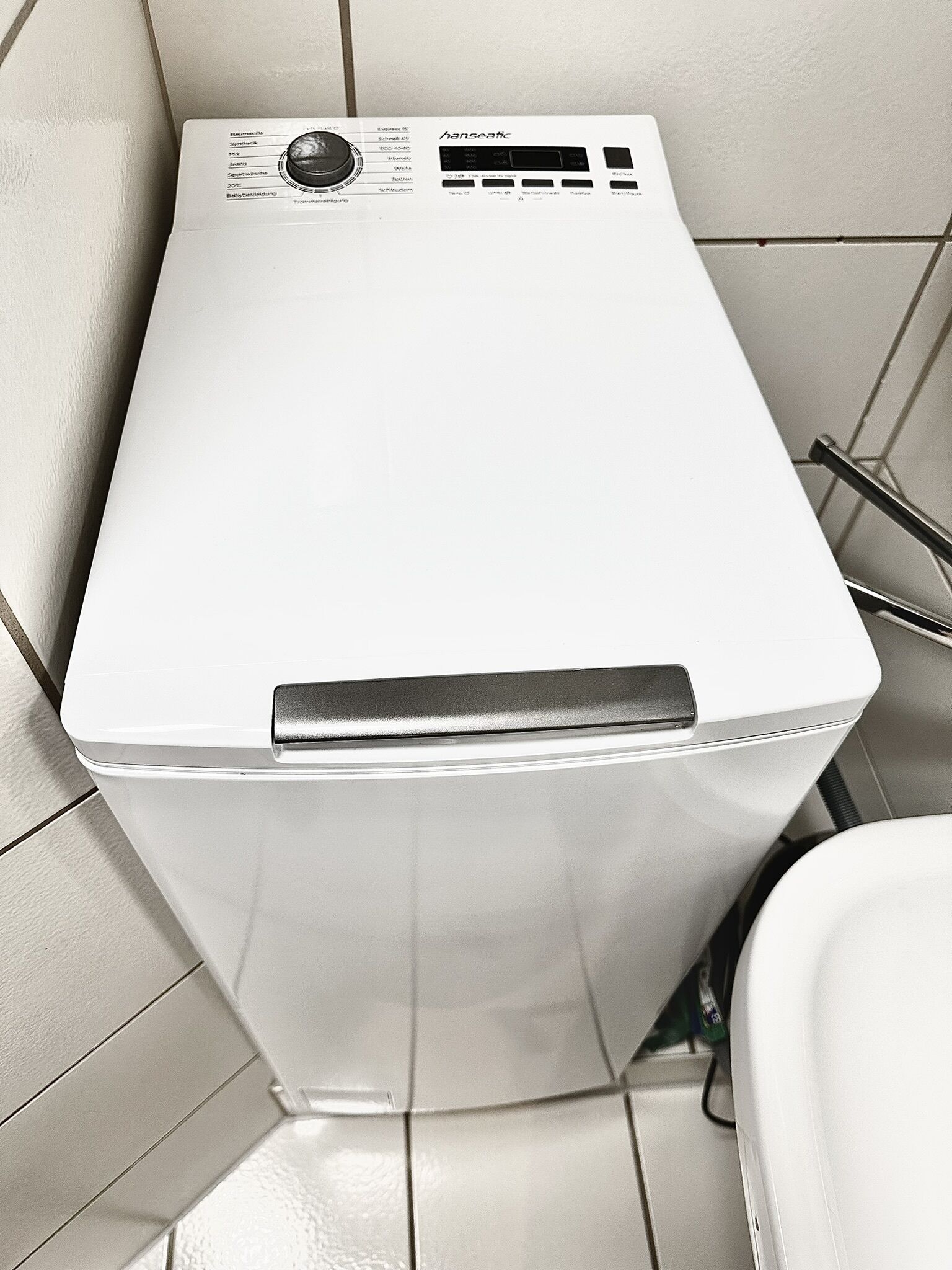 A compact, white, wall-mounted heating unit with a control panel featuring multiple settings and a digital display.