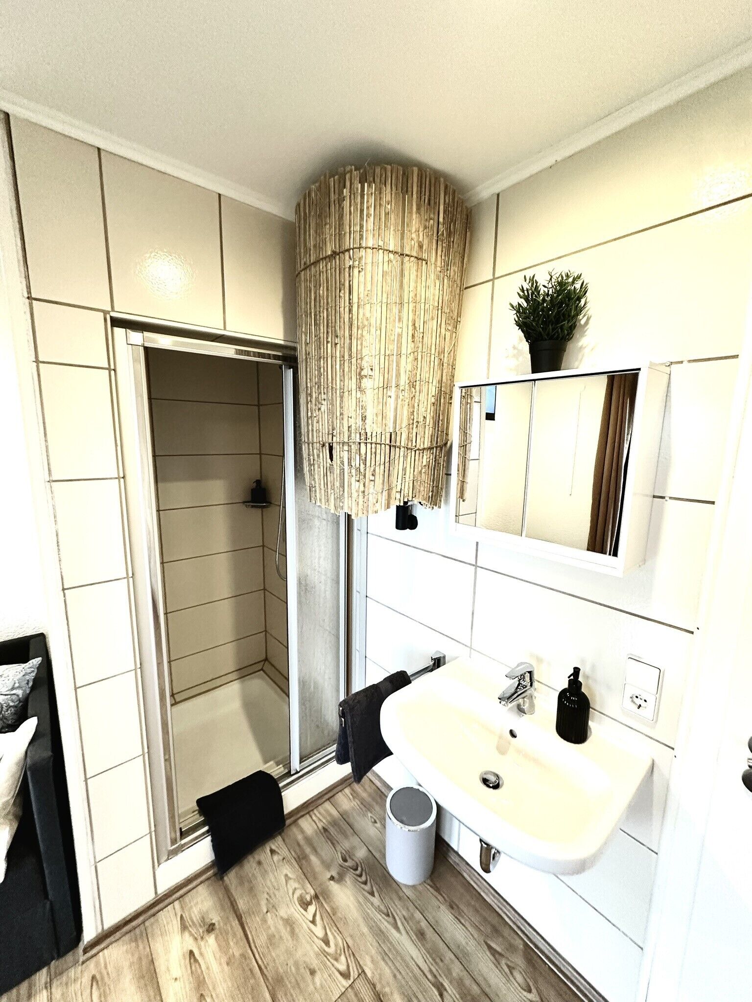 Un bagno moderno con doccia, lavandino e specchio.