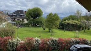 A residential area with a house, green lawn, and trees.