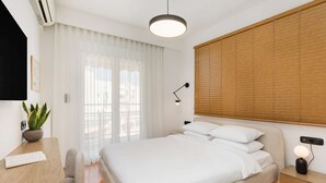 Un dormitorio moderno con cama, mesita de noche, lámpara y una planta en maceta.