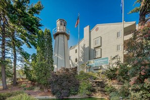 Un edificio con una torre de faro, una bandera y un letrero que dice "Lighthouse Cove".