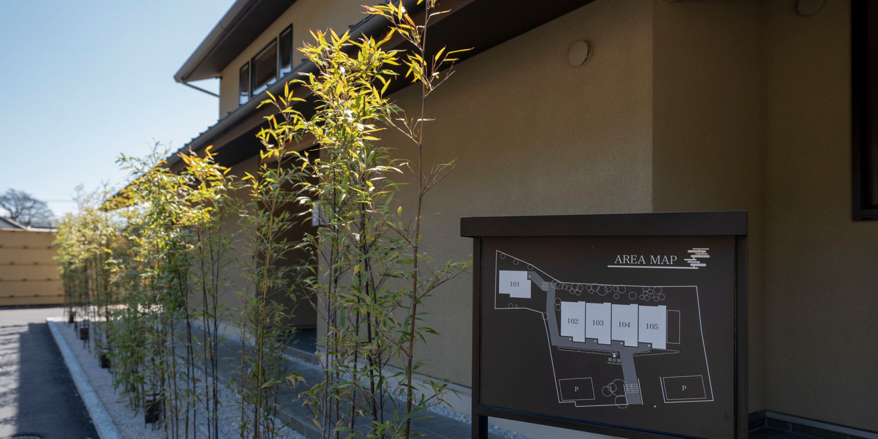A building with a sign indicating an area map with numbered rooms and parking spaces.