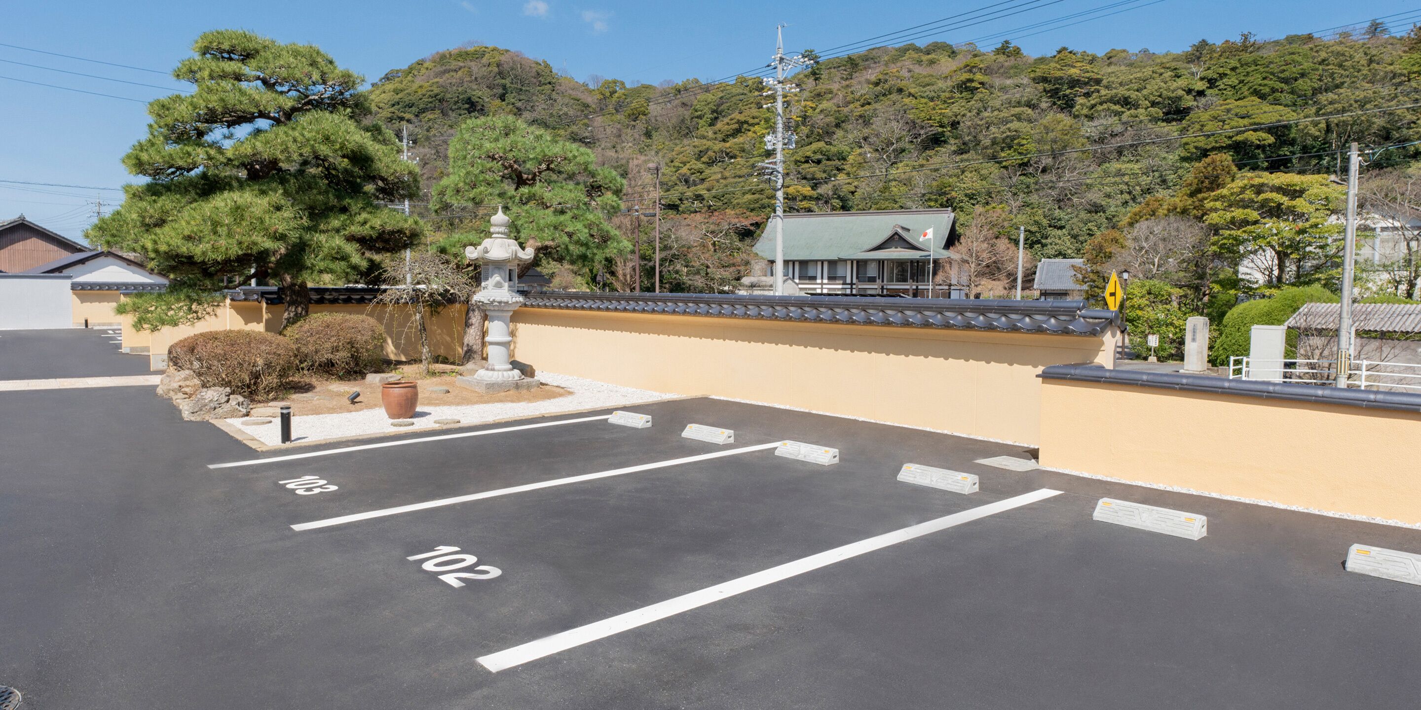 A parking lot with clearly marked spaces and a traditional building in the background.
