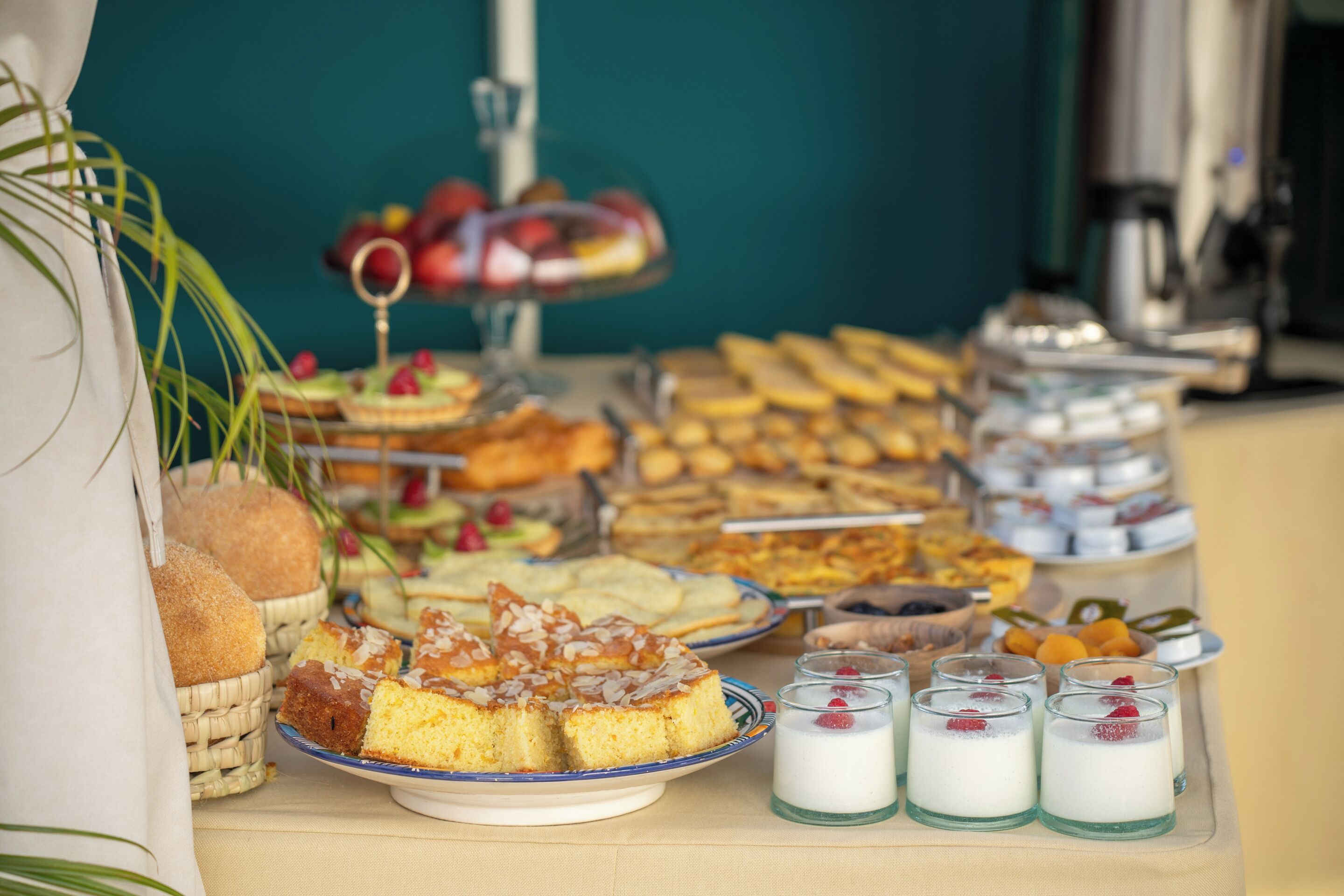 Una mesa de buffet con diversas opciones de comida, incluyendo pasteles, repostería y postres.