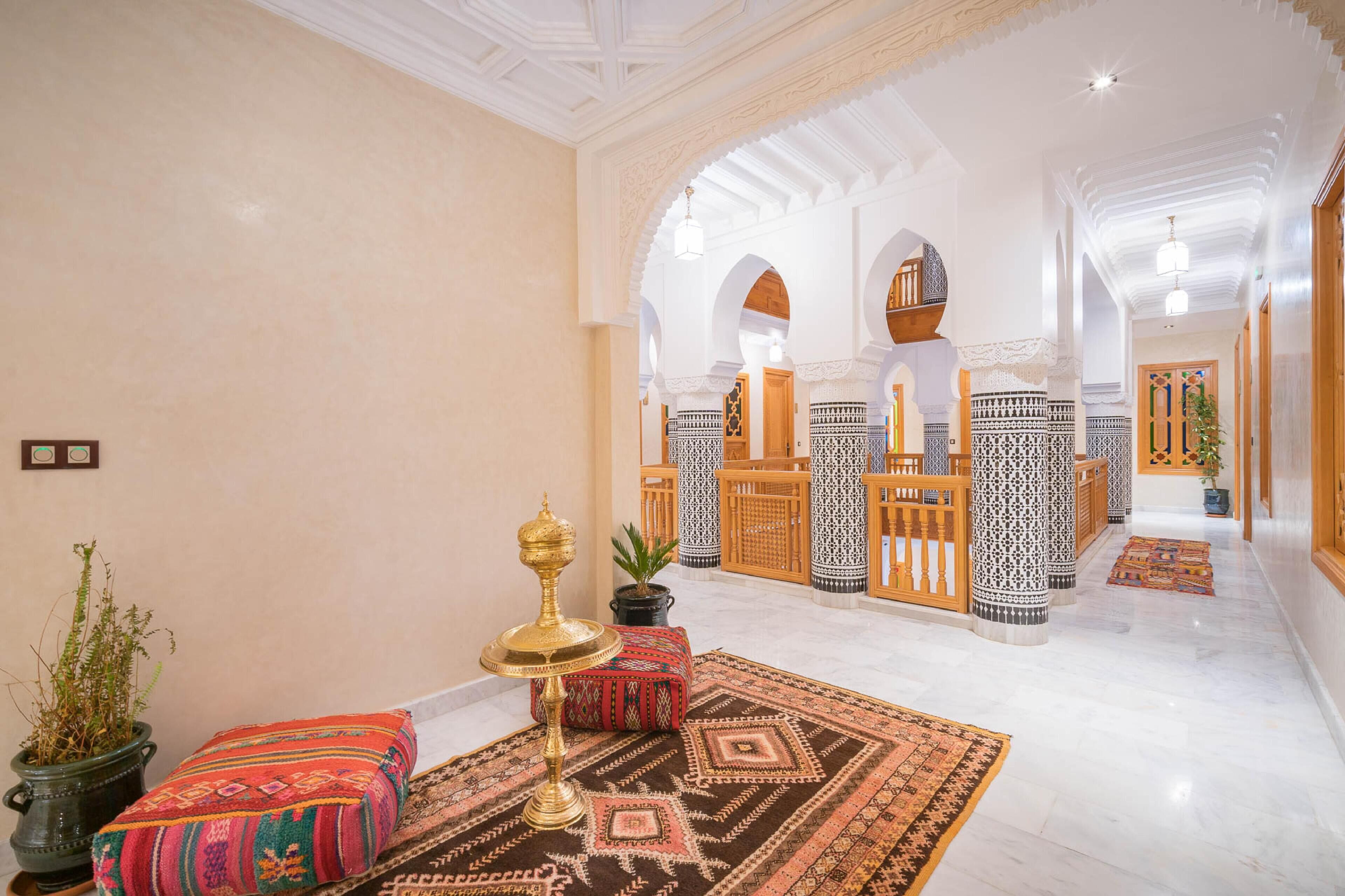 A spacious lobby with a high ceiling, ornate columns, and a patterned carpet.