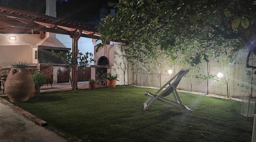 A well-maintained outdoor patio area with a pergola, a swing set, and a barbecue grill.