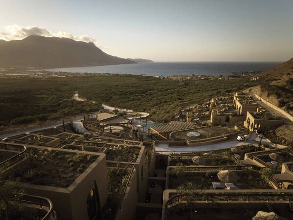 A resort with terraced buildings, a swimming pool, and a view of the sea and mountains. - Tella Thera, a Member of Design Hotels (Kissamos)