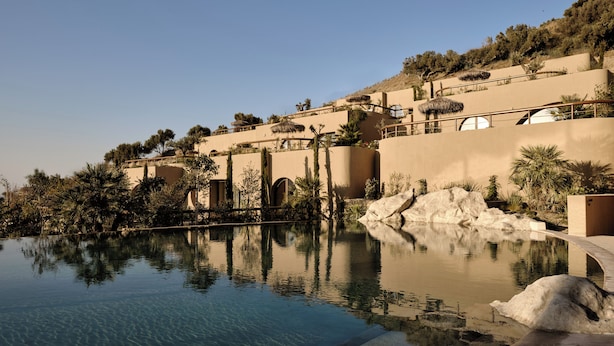 Ein Resort mit Schwimmbad, Felsformationen und mediterranem Architekturstil.