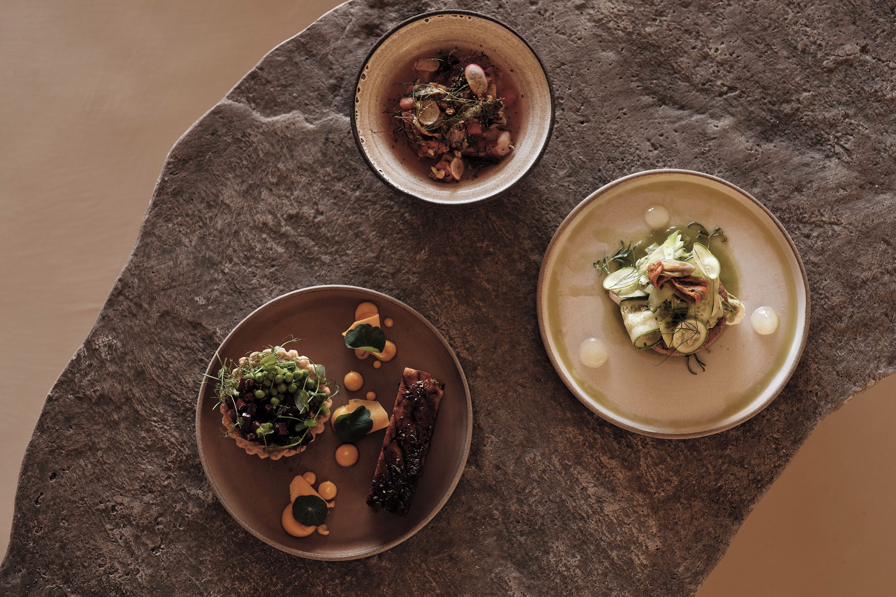Three dishes on a stone table.