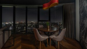 Een moderne eetruimte met uitzicht op de stad, een ronde tafel en vier stoelen.