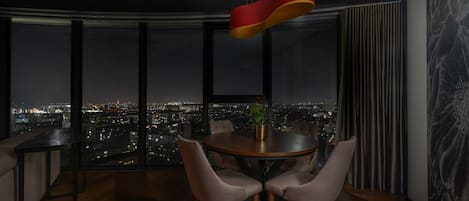 Un comedor moderno con vistas a la ciudad, una mesa redonda y cuatro sillas.
