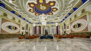 Eine großzügige Lobby mit Marmorboden, aufwendiger Decke und Sitzbereichen.