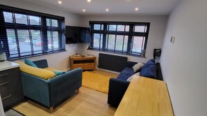 A modern living room with a sofa, a coffee table, and a TV.
