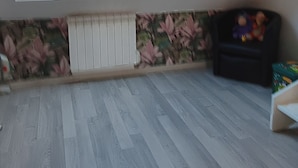 Una stanza con soffitto spiovente, lucernario, termosifone e parete decorata.