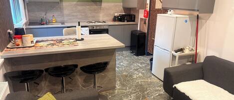 Un espace de vie compact comprenant une cuisine, un coin repas et un coin salon.