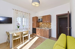 A compact living space with a dining area, kitchenette, and a bed. - Holiday apartment with air conditioning and outdoor pool (Fažana)