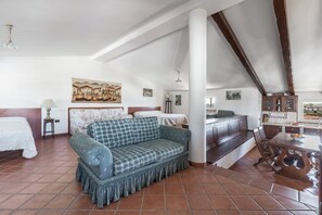 A spacious living area with a sofa, a dining table, and a kitchen in the background.
