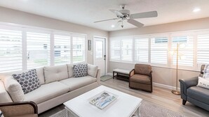 A living room with a sofa, armchair, coffee table, and a ceiling fan. - Villa 20 - Premium Plus (Siesta Key)